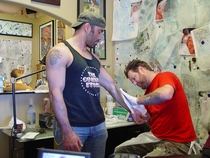 Joe Rogan Rage Face Tattoo at the Top of  the Left Arm